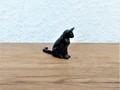 Miniature chat noir assis