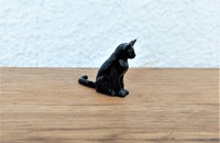 Miniature chat noir assis