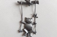 Broche chat sur une balançoire